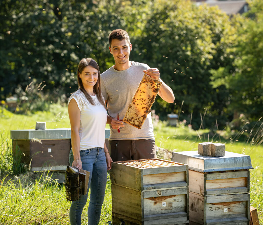 Imkerpaar bei der Arbeit an den Bienenstöcken – nachhaltige Bio-Imkerei der Honigwanderer im Bayerischen Wald, transparente und handwerkliche Honigherstellung.