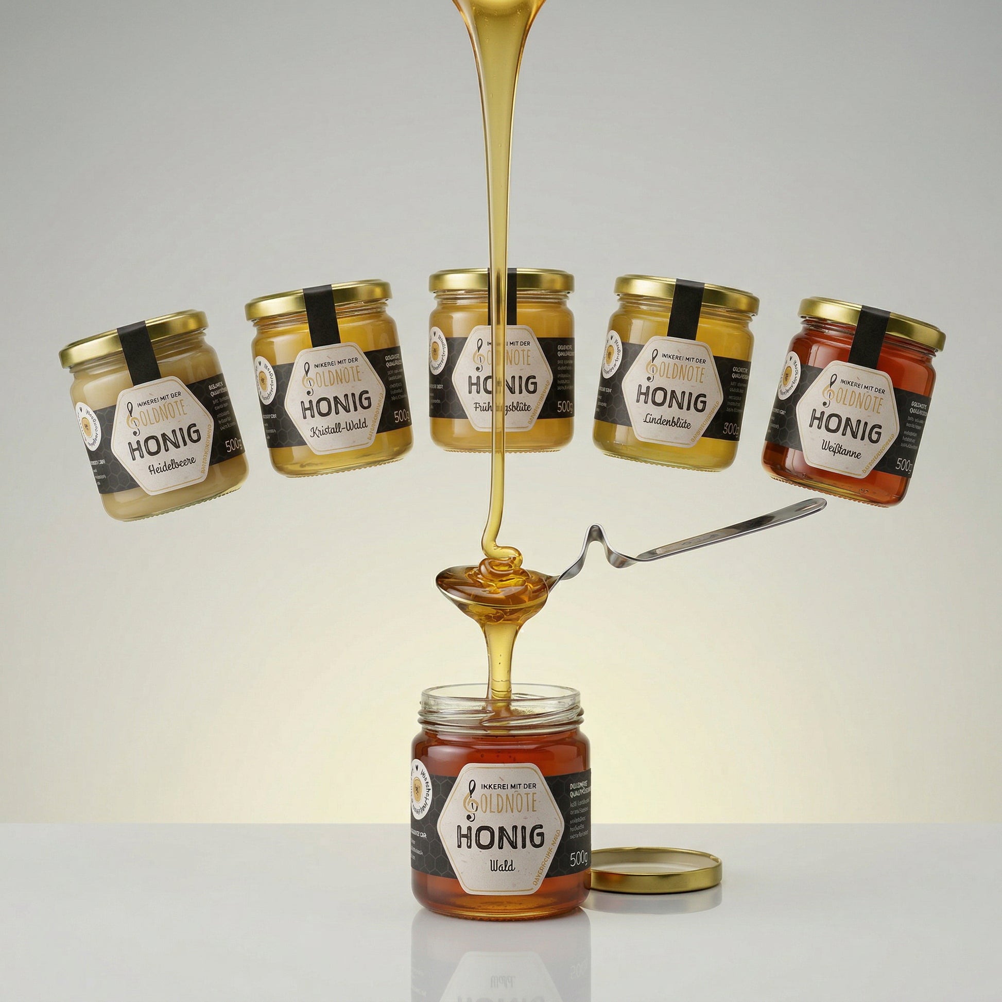 Goldnote 6er Symphonie Honigset mit verschiedenen Honigsorten, dargestellt mit fließendem Honig und mehreren Honiggläsern