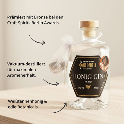 Flasche Goldnote Honig Gin mit Bronze-Auszeichnung der Craft Spirits Berlin, umgeben von Beschriftungen wie „vakuum-destilliert“ und „Weißtannenhonig & edle Botanicals“ auf hellem Holztisch.