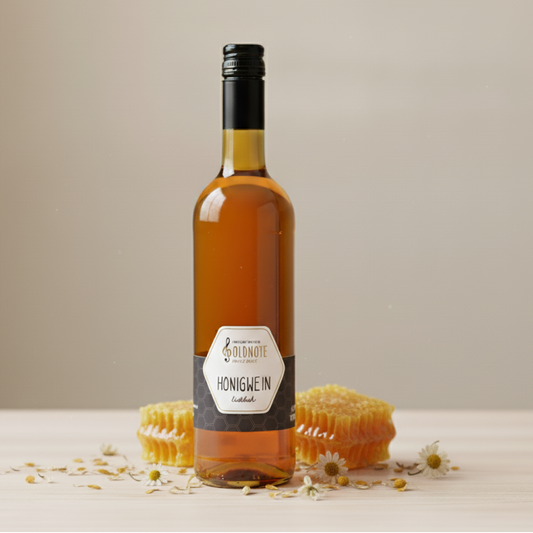 Flasche Goldnote Honigwein vor Wabenstücken und Kamillenblüten auf einem Holztisch – hochwertiges Produktbild eines milden Honigweins.